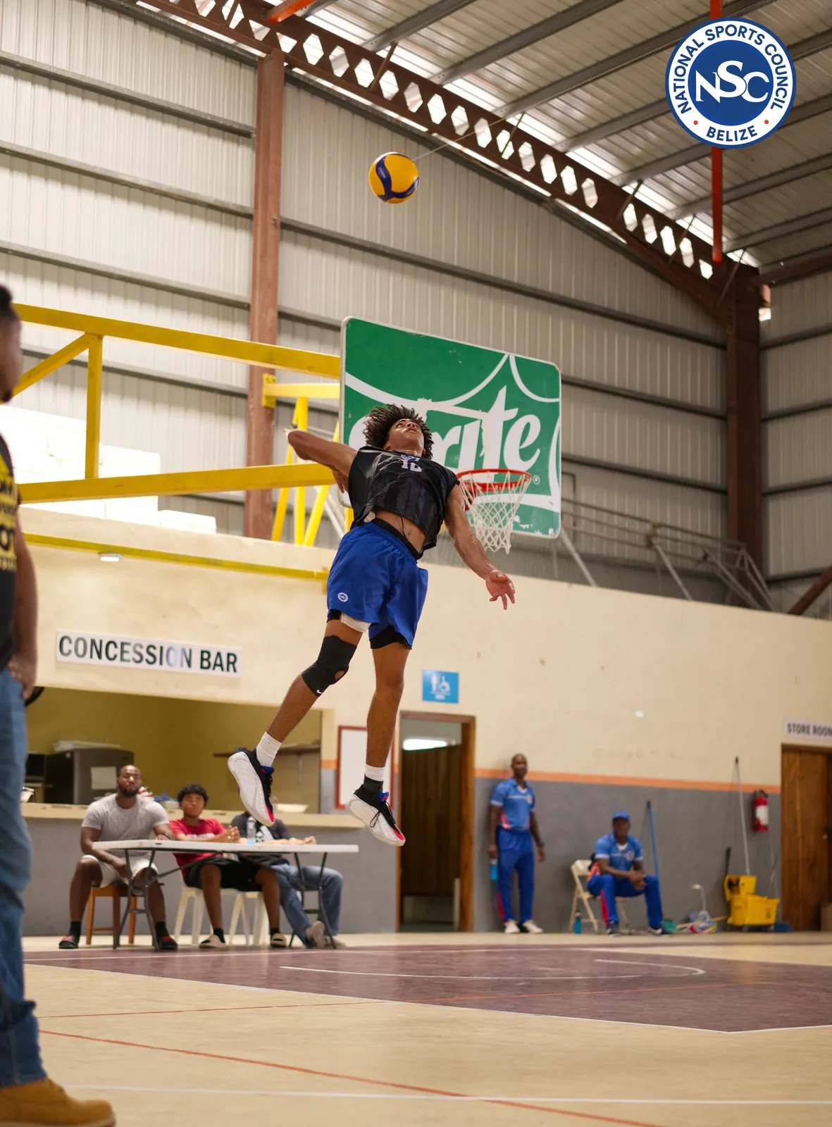 A volleyball player spiking the ball during an indoor match at the NSC Super Nationals
